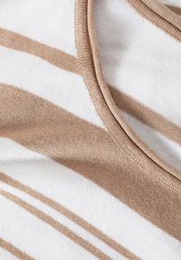 Puuvillasegu kangas, millel on horisontaalsed beežid ja valged triibud, ümar kaelus ja sile tekstuur. Erosenud õmblused on nähtavad.