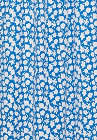 Modrá tkanina s hustým vzorem malých bílých květin a občasnými poupaty, vytvářející živou květinovou texturu.