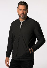Svart zip-up bomberjacka med rund krage, ribbade ärmslut och sidofickor. Tillverkad av slätt, lätt tyg med en enkel design.