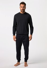 Granatowy sweatshirt w białe kropki, okrągły dekolt i ści�ągacze na mankietach, w połączeniu z pasującymi granatowymi spodniami dresowymi z bocznymi kieszeniami.