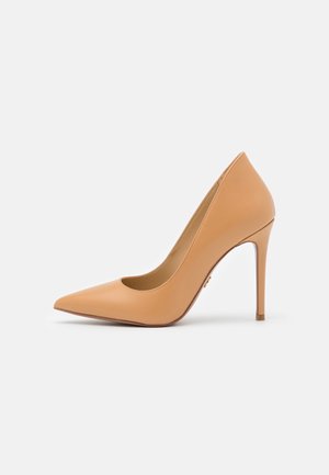 Beige pumps med spids tå og høje hæle, slank stilet hæl, glat læderfinish og lukket bagside.
