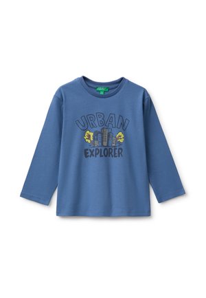 Camiseta azul de manga larga para niños con texto ""Urban Explorer"" y un gráfico de edificios de la ciudad y dos árboles amarillos en la parte delantera.