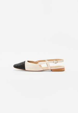 Chaussure plate pour femme à bride arrière avec un bout pointu noir texturé, corps en cuir crème, bride latérale avec boucle et petit talon en bois.