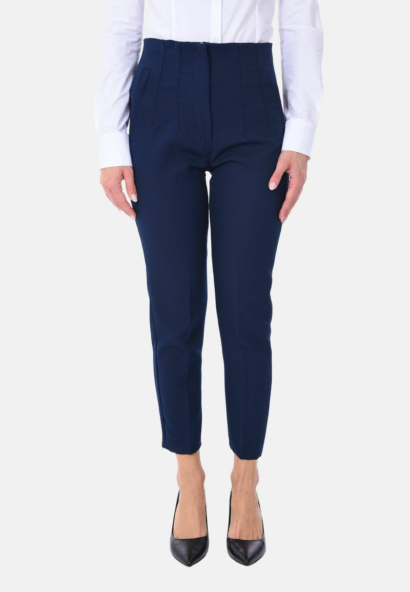 Pantaloni blu navy con una vestibilità sartoriale, caratterizzati da pince, tasche laterali e chiusura con zip. Abbinati a decolleté nere a punta.