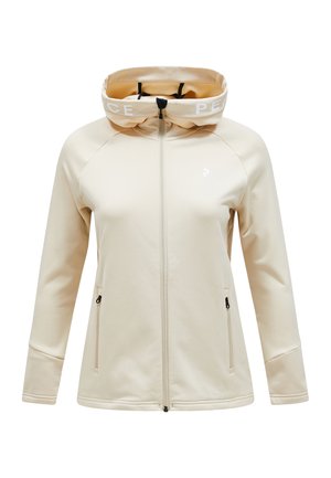 Beige zip-up jacket with a hood, featuring a white "PEACE" band, raglan sleeves, and two zippered side pockets. Smooth texture, minimalist design.