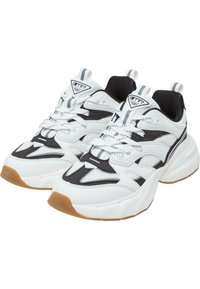 Masywne sneakersy z białą i czarną siateczką, gumową podeszwą i sznurowanym zapięciem; charakteryzują się akcentowanymi detalami oraz teksturowanym wykończeniem.
