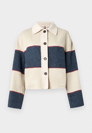 Veste courte à boutons crème et marine, avec de larges rayures horizontales et une texture douce. Col classique et cinq boutons sur le devant.