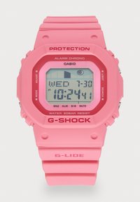 Montre digitale rose avec un cadran carré, un bracelet en silicone texturé et une bordure rouge. Les caractéristiques incluent une alarme, une résistance à l'eau et une lumière LED.