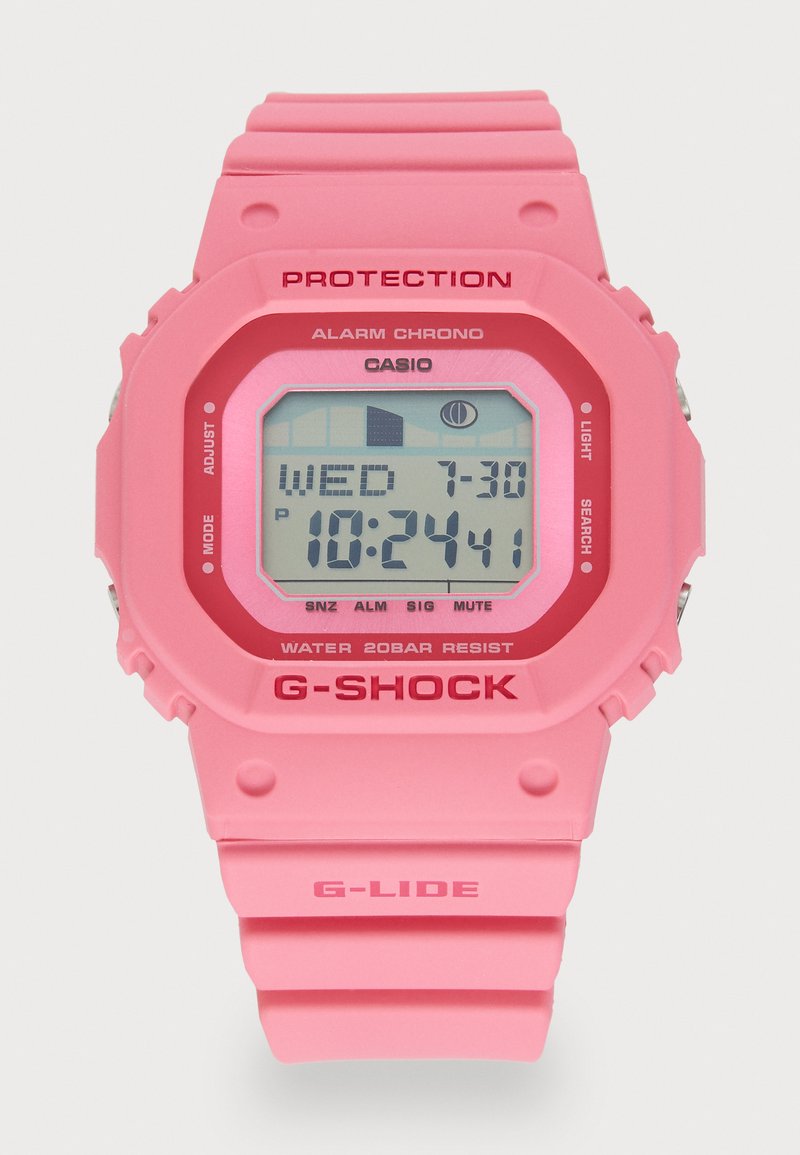 Montre digitale rose avec un cadran carré, un bracelet en silicone texturé et une bordure rouge. Les caractéristiques incluent une alarme, une résistance à l'eau et une lumière LED.