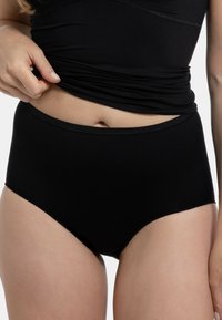 Perizoma nero a vita alta realizzato in tessuto liscio, con un design senza cuciture e una morbida fascia in vita per comfort e vestibilità sicura.