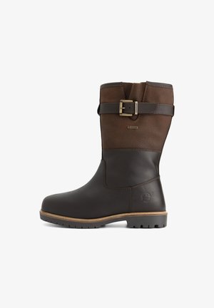 Mittelhohe braune Lederstiefel mit dunklerem braunem Schaft, Messing-Schnallengurt, strukturiertem Fußbett und dezent eingeprägtem Logo an der Ferse.