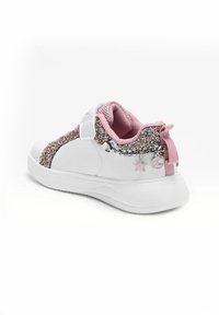 Scarpa sportiva bianca con dettagli rosa, decorazioni glitterate sui lati e un'accattivante catena argentata. Presenta una chiusura in velcro e una suola testurizzata.
