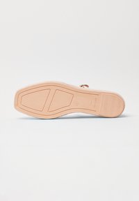 Suola di sandalo in beige chiaro con motivo geometrico del battistrada, numero 37, e "Made in Spain" inciso vicino al tallone.