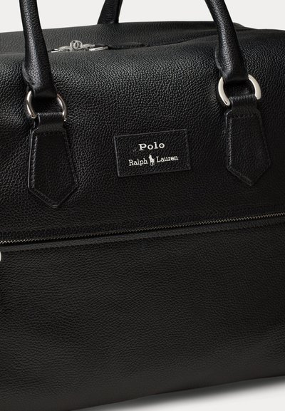 Czarna, teksturowana skórzana torba Polo Ralph Lauren z srebrnym zamkiem błyskawicznym i podwójnymi uchwytami przymocowanymi srebrnymi pierścieniami.
