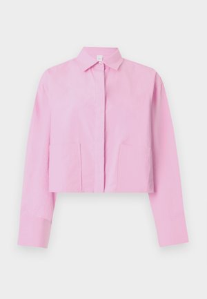 Camicia corta rosa con collo a risvolto, maniche lunghe e due tasche frontali. Realizzata in tessuto leggero con una texture liscia.