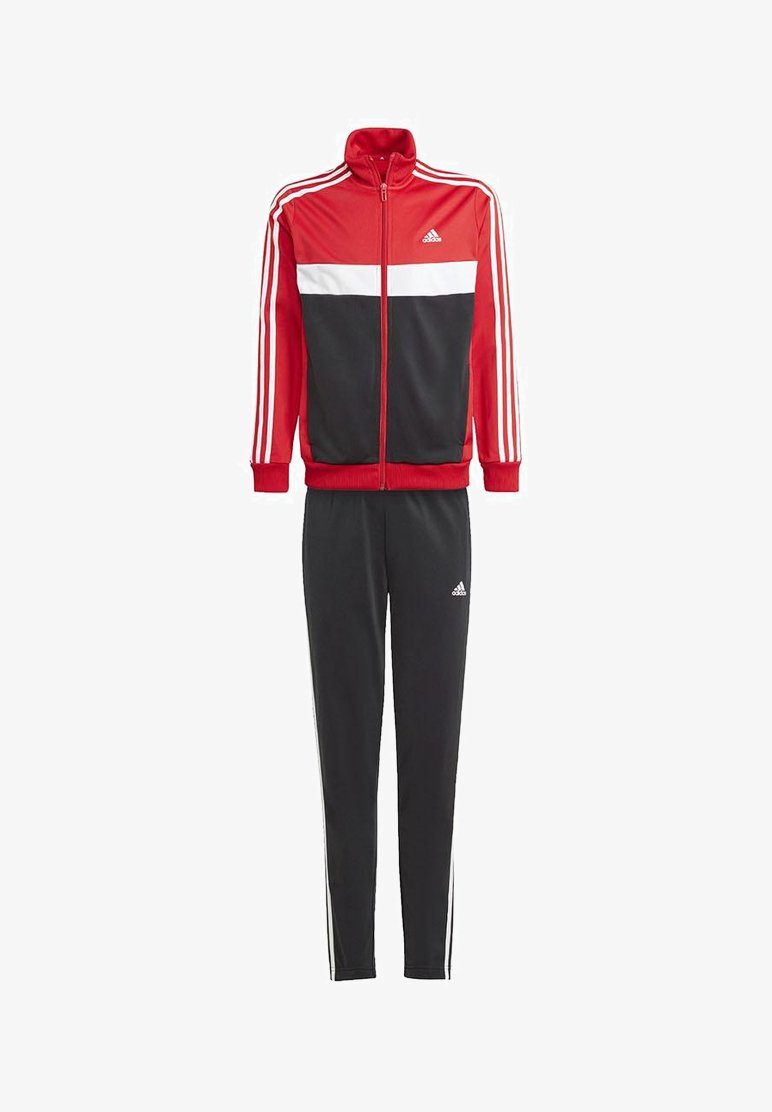 Crvena i crna Adidas trenirka s bijelim prugama. Jakna ima zatvarač sprijeda i rebraste manžete; hlače imaju sužen kroj s detaljima logotipa.