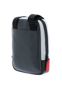 Borsa in pelle nera con accenti grigi, forma quadrata, tracolla regolabile, chiusura con zip superiore e un cursore rosso. Texture liscia.