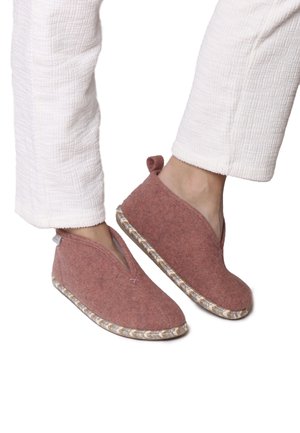 Wool slippers in dusty pink with a V-shaped opening, textured surface, and a braided rubber sole for grip. Small loop detail at the back.