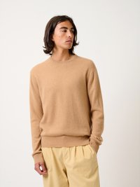Baumwollmischung Pullover, camel Farbe, Rundhalsausschnitt, gerippte Bündchen und Saum, weiche Textur, getragen mit hellgelben Hosen.