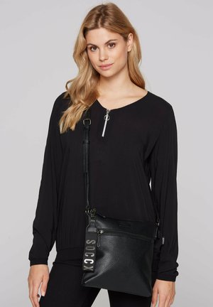 Schwarze Umhängetasche aus strukturiertem Leder mit Reißverschluss, einer Fronttasche und einem Tragegurt mit "SOCCX"-Aufschrift.