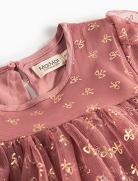 Różowa sukienka z teksturowanym, warstwowym wzorem, złotymi nadrukami oraz zapięciem na guziki z tyłu. Miękka tkanina z przezroczystą nakładką.