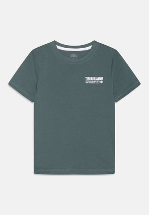 Camiseta de manga corta Timberland de color verde oscuro con cuello redondo y logo en texto blanco en el lado izquierdo del pecho.