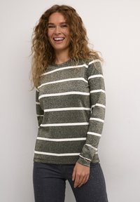 Maglietta a maniche lunghe a righe verde scuro con righe bianche, realizzata in un tessuto testurizzato. Abbinarla a jeans grigi scuri con dettagli in borchie.