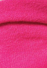 Tissu texturé rose vif avec une apparence douce et duveteuse. Le matériau est épais et moelleux, avec un motif de tissage uniforme.