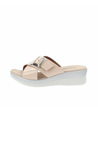 Sandalia deslizante de charol beige con una correa ancha y detalle de hebilla plateada sobre una suela de cuña blanca, con una superficie texturizada.