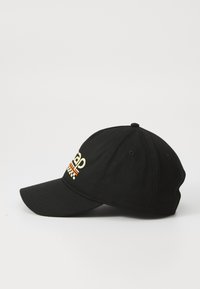 Șapcă de baseball neagră din bumbac, cu text brodat colorat și un model în carouri. Vizor curb și curea ajustabilă în spate.