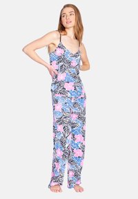 Conjunto de pijama que presenta un fondo negro con patrones florales en azul y rosa. Tirantes tipo espagueti en la parte superior y pantalones sueltos con un ajuste relajado.