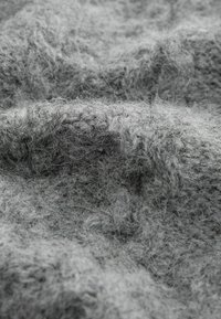 Gray wool fabric with a soft, textured surface. Visible fibers create a fuzzy appearance, showcasing a blend of light and dark gray tones.