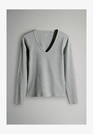 Hallikas pikkade veelkonna V-kaelusega sviiter, ribakujulise tekstuuriga, kerge kangas, sirge äär ja külgede lõiked puusade juures.