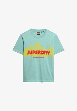 Lichtblauw kortmouw t-shirt met een gele palmboom graphic en vet rood "SUPERDRY"-tekst gecentreerd op de voorkant.