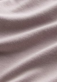 Svijetli mauve materijal s mekom teksturom, s finim uzorkom tkanja i blagim naborima.