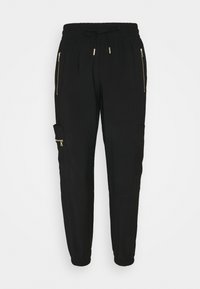 Schwarze Jogginghosen mit elastischem Bund, Kordelzug, seitlichen Reißverschlusstaschen und einer Cargotasche. Aus einem glatten, strapazierfähigen Stoff gefertigt.