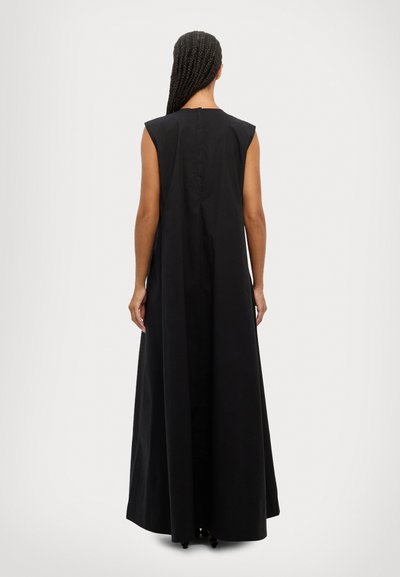 Black sleeveless maxi dress with a simple, loose fit, featuring a straight hem and a discreet button closure at the back. Smooth texture.
