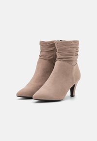 Botas de tobillo de ante beige con parte superior arrugable, puntera afilada y un tacón cuadrado de 6.5 cm, que cuentan con una cremallera lateral para el cierre.