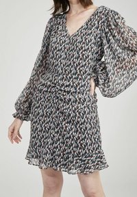 Jurk met korte mouwen en een V-hals, met een meerkleurig, abstract patroon. Gemaakt van lichtgewicht stof met een rucheszoom en volumineuze mouwen.