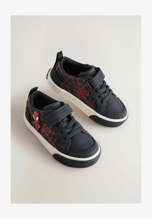 Zapatillas negras con un diseño de telaraña roja. Presentan un gráfico de Spider-Man, cierres de cordones y velcro, y una suela de goma blanca con agarre texturizado.