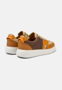 Sneakers con lacci in pelle e tessuto marroni, beige e arancioni, con una finitura testurizzata e una suola in gomma bianca. Presentano accenti di design trasparenti.