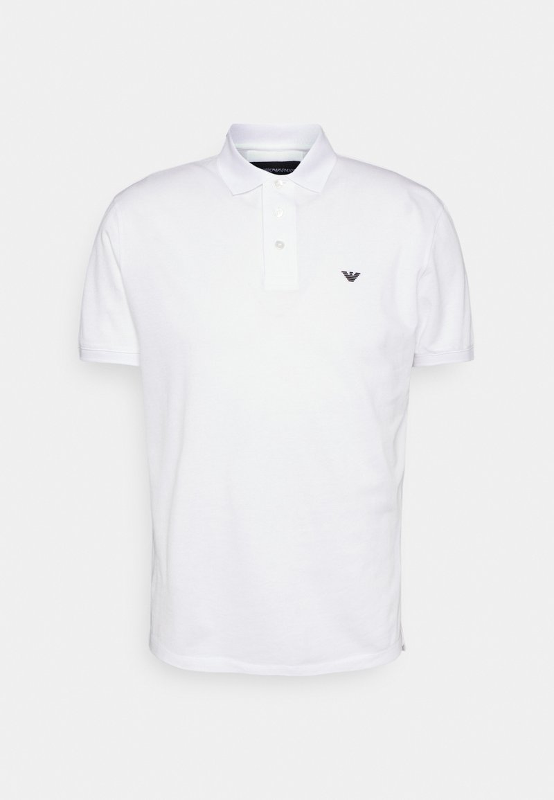 Balts polo krekls no kokvilnas, ar klasisku apkakli, trīs pogu aizdari un nelielu melnu logotipu kreisajā krūtī.