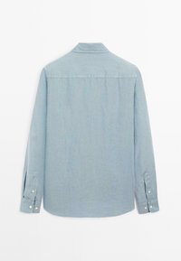 Chemise à manches longues bleu clair avec un col boutonné, des poignets à deux boutons et un ourlet arrondi ; fabriquée dans un tissu doux et texturé.
