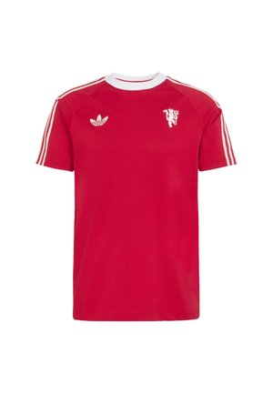 Czerwona sportowa koszulka z krótkim rękawem, białym okrągłym dekoltem, logo Adidas na lewej piersi, emblemat lwa na prawej piersi oraz trzema białymi paskami na rękawach.