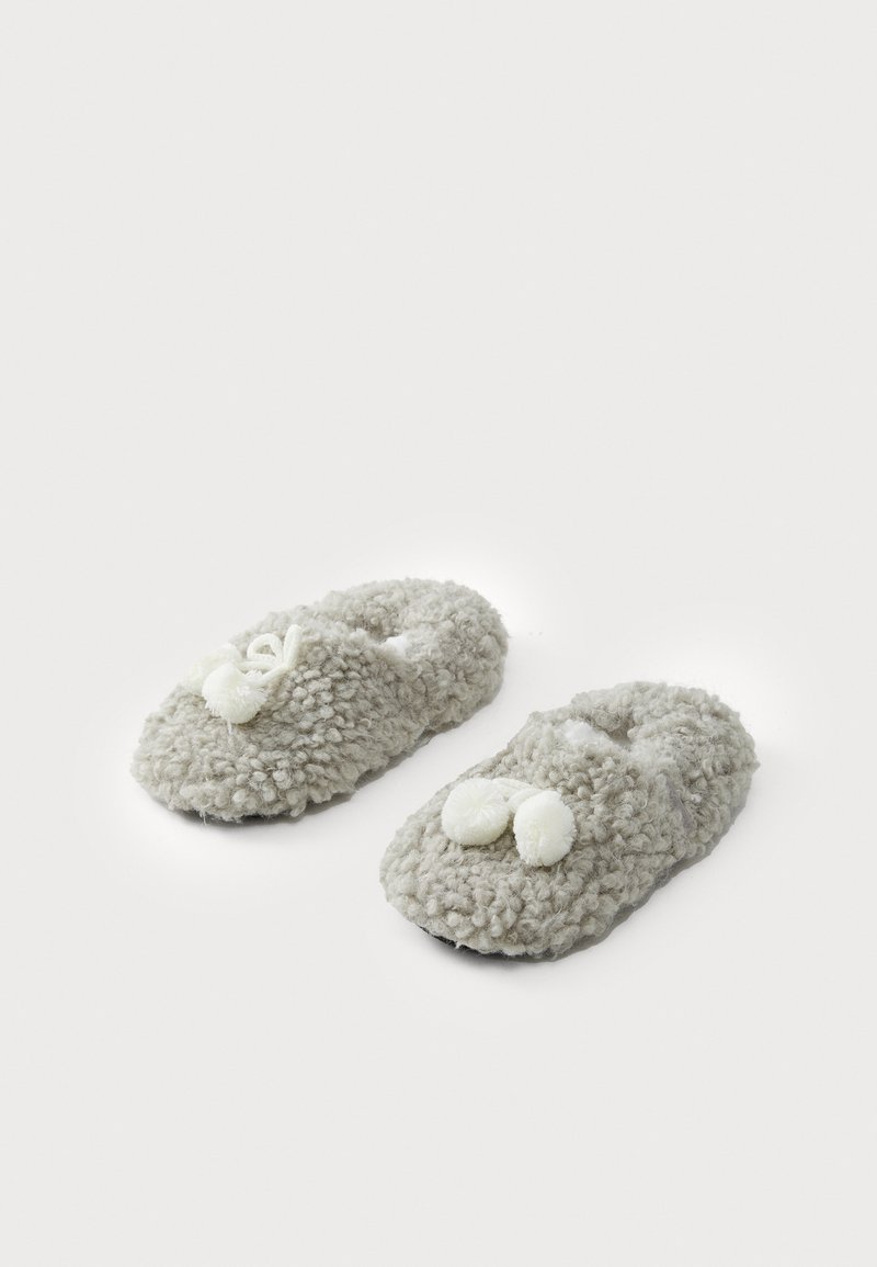 Pantofole grigie morbide e pelose con una finitura a trama soffice. Tra le caratteristiche ci sono due pompon bianchi sulla parte anteriore e un design con retro aperto.