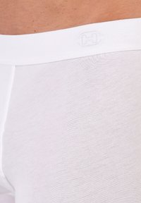 Białe bawełniane bokserki z miękkim, elastycznym pasem w subtelnym logo; gładka tekstura i dopasowany krój.