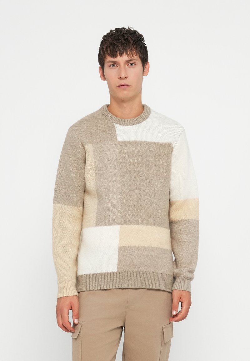 Πλεκτή μπλούζα με γεωμετρικό σχέδιο σε μπεζ, κρέμα και υπόλευκες αποχρώσεις. Στρογγυλή λαιμόκοψη με ριμπε τέρματα και στρίφωμα.