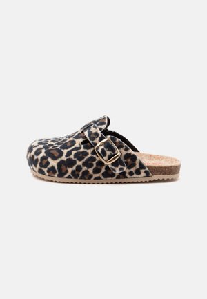 Pantoffel im Clog-Stil mit Leopardenmuster, Korksohle, verstellbarem goldfarbenem Schnallenriemen und geschlossener Zehenpartie, im Profil auf weißem Hintergrund gezeigt.
