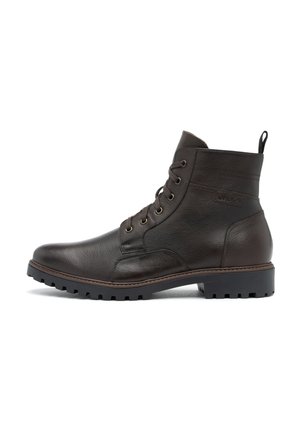 Botas de tobillo de cuero marrón con punta redonda, parte delantera con cordones y suela gruesa de goma negra. Presentan costuras decorativas y una lengüeta.