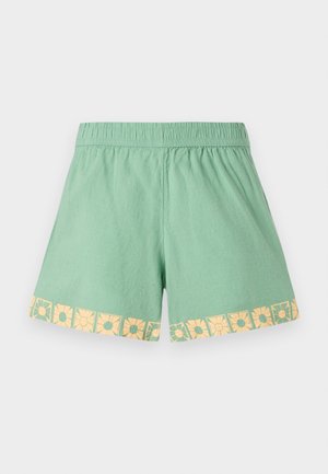 Ljusgröna shorts med resårmidja och ett blommönster i gult längs fållen. Mjuk, lätt tyg med en avslappnad passform.